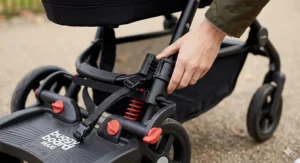 Close-up of a universal buggy board connector being secured to a pram frame.