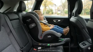 A photorealistic 4K photograph of a toddler correctly secured in a rear-facing Joie i-Spin 360 i-Size car seat within a Volvo XC60. A label indicates 'Rear-Facing: Up to 105 cm / Approx. 4 Years,' highlighting extended rear-facing as the safest travel method for toddlers in the UK.