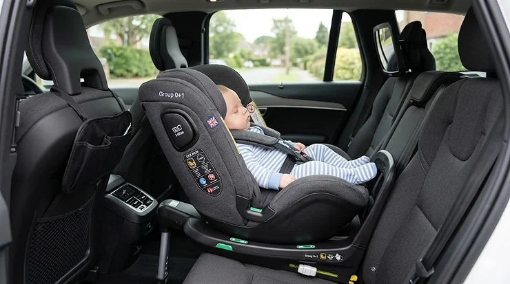 A multi-stage Group 0+1 car seat installed in a modern family car, showing the rear-facing position for newborns. group 0+1 car seat