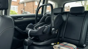 Detailed view of a Maxi-Cosi car seat securely clicking into a FamilyFix 360 Isofix base within a car interior.