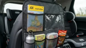 Alt text for image 5: A car seat organiser fully packed with snacks, water bottles, and books for a long family drive.