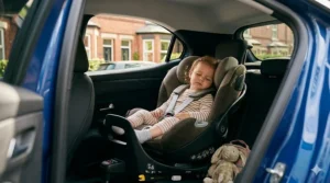 A sleeping toddler is positioned comfortably in a rear-facing Cybex Sirona Gi i-Size car seat, showing the extended rear-facing legroom inside the car cabin.