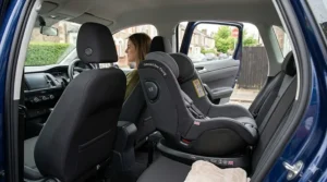 A compact rear-facing car seat leaving enough legroom for the front-seat passenger in a small estate.
