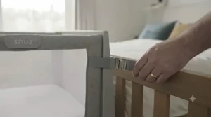 Demonstrating the safety strap system used to secure the cribs to an adult bed frame.