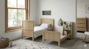A young child sleeping in a converted cot bed that has been adjusted for a toddler.