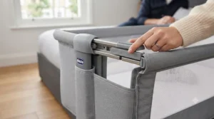 Close-up of the one-handed sliding side panel mechanism on the Chicco Next2Me Magic.