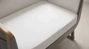 Detail view of the firm, flat mattress inside the safest co-sleeping crib for healthy infant sleep.