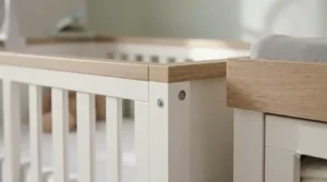 Close-up of the smooth oak veneer finish on a contemporary nursery furniture set.
