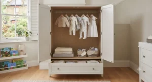 Open nursery wardrobe interior with hanging rail and shelves.