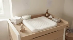 A practical nursery changing station styled with a soft changing mat and minimalist organization.