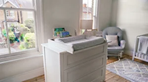 Stylish wooden chest of drawers with top changer matching contemporary neutral UK nursery decor.