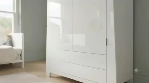 Contemporary white high-gloss nursery wardrobe reflecting natural light in a spacious bedroom.