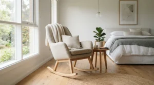 A stylish grey nursing chair under £150 featuring wooden rocking legs in a neutral bedroom.